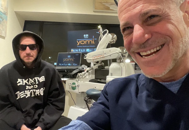 Man in hoodie and smiling person in office