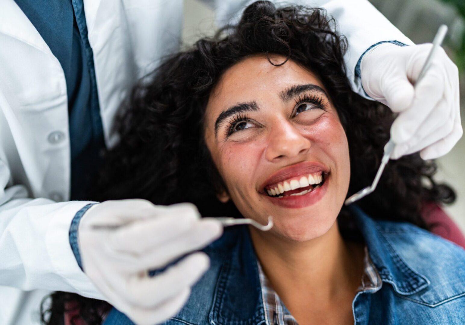 Dentist examining young patient woman teeth at dentist's office